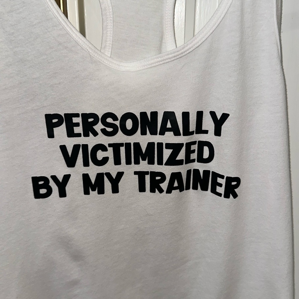 White tank “. Personally victimized by my Trainer”.